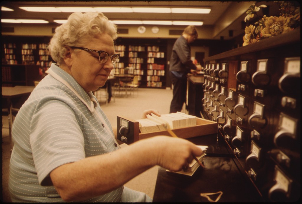 LIBRARIAN_AT_THE_CARD_FILES_AT_SENIOR_HIGH_SCHOOL_IN_NEW_ULM_MINNESOTA._THE_TOWN_IS_A_COUNTY_SEAT_TRADING_CENTER_OF..._-_NARA_-_558218